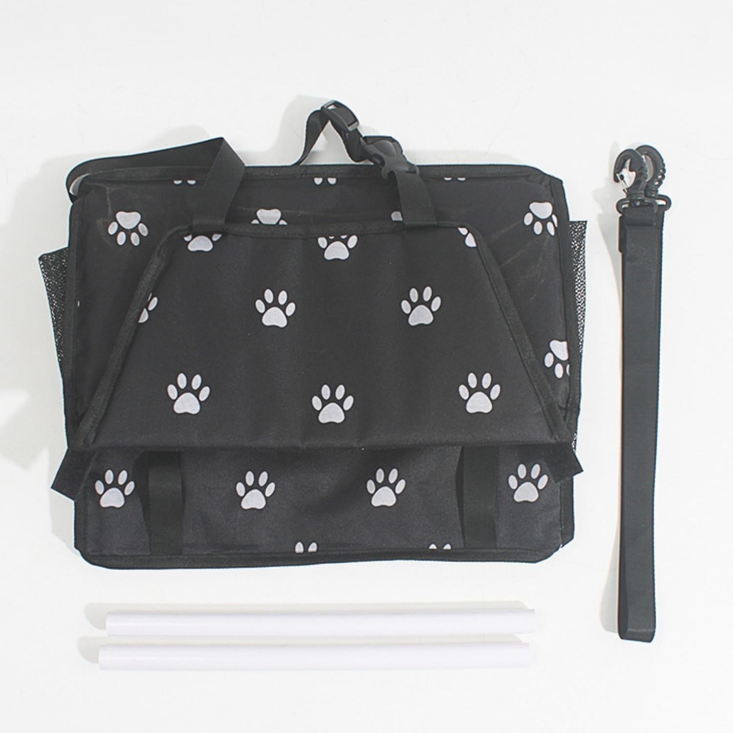 Opgevouwen zwarte autostoel voor honden met witte pootafdrukken en onderdelen